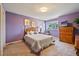 Cozy bedroom featuring carpeted floors, soft natural lighting, and lavender accent wall at 426 Buena Vista Rd, Golden, CO 80401