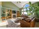 Spacious living room with large windows, vaulted ceilings, a brick fireplace, and comfortable leather seating at 426 Buena Vista Rd, Golden, CO 80401
