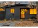 Close-up of a cozy home's entrance, showcasing a warm wooden door, stylish lighting, and well-maintained landscaping at 8120 W 54Th Pl, Arvada, CO 80002