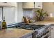 Close-up of the stainless steel stove and stone countertops in the modern kitchen at 8120 W 54Th Pl, Arvada, CO 80002