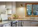 Bright kitchen with a gas range, stone countertops, wood window trim, and a brass faucet for a modern touch at 8120 W 54Th Pl, Arvada, CO 80002