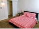 Bedroom with carpet, a bed with red patterned bedding, and a closet with sliding doors at 9240 E Girard Ave # 1, Denver, CO 80231
