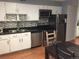 This kitchen features stainless appliances, white cabinets, decorative tile backsplash, and dark countertops at 9240 E Girard Ave # 1, Denver, CO 80231