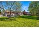 Expansive backyard with lush green lawn, mature trees, and a charming patio area for outdoor enjoyment at 6655 S Elm Cir, Centennial, CO 80121