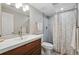 Full bathroom with wood-look vanity and shower with patterned curtain at 6655 S Elm Cir, Centennial, CO 80121