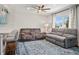Bright living room with modern furniture, stylish ceiling fan, and natural light from the window at 6655 S Elm Cir, Centennial, CO 80121