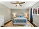 Cozy bedroom featuring hardwood floors, a ceiling fan, and a comfortable bed with side tables at 6655 S Elm Cir, Centennial, CO 80121