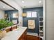Stylish bathroom with an ornate mirror, modern sink, and dark blue accent wall at 1594 S Locust St, Denver, CO 80224