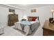 A simple bedroom is furnished with neutral furniture and a patterned bedspread, creating a cozy retreat at 1594 S Locust St, Denver, CO 80224