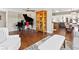 Open-concept living space featuring hardwood floors, a piano, and a view into the dining area at 1594 S Locust St, Denver, CO 80224