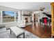Bright living room features a fireplace, piano, large window, and hardwood floors at 1594 S Locust St, Denver, CO 80224