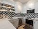 Bright kitchen with white cabinets, stainless steel appliances, and a black and white patterned backsplash at 345 Fillmore St # 407, Denver, CO 80206