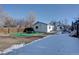 Snowy backyard with patio and partial house view at 939 Knox Ct, Denver, CO 80204