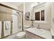 Bathroom with white cabinets, framed mirror, tiled shower and tub with white fixtures at 1309 Alexandria St, Lafayette, CO 80026