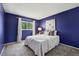 Bright bedroom with soft carpet, purple accent wall and a comfortable bed at 1309 Alexandria St, Lafayette, CO 80026