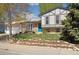 Charming two-story home with a manicured lawn, rock garden, blue front door, and a spacious two-car garage at 1309 Alexandria St, Lafayette, CO 80026