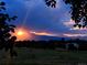 Vibrant sun setting over the distant mountains framed by silhouetted branches at 1309 Alexandria St, Lafayette, CO 80026