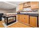 Basement wet bar with sink, mini fridge, barstool seating, and stone backsplash at 16084 Stonebriar Dr, Parker, CO 80134