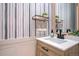 Charming bathroom features stylish wallpaper, a modern vanity, and sleek black hardware at 16084 Stonebriar Dr, Parker, CO 80134