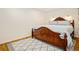 Comfortable bedroom with a dark wood bed frame, hardwood floors, a decorative rug and modern sconce lighting at 16084 Stonebriar Dr, Parker, CO 80134