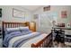 Bright bedroom featuring a wooden bed frame, study desk and chair setup, and a window with natural light at 16084 Stonebriar Dr, Parker, CO 80134