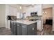 Well-lit kitchen features white cabinets, stainless steel appliances, and a gray island with a granite countertop at 16084 Stonebriar Dr, Parker, CO 80134
