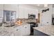 Bright kitchen boasts granite countertops, mosaic backsplash, stainless steel appliances and wood flooring at 16084 Stonebriar Dr, Parker, CO 80134