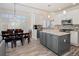 Open kitchen and dining area with wood floors, granite counters, white cabinets, and stainless appliances at 16084 Stonebriar Dr, Parker, CO 80134