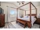 Spacious bedroom featuring a wooden canopy bed, sitting bench, and large window with natural light at 16084 Stonebriar Dr, Parker, CO 80134