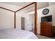 Open bedroom with a wooden canopy bed, TV, dark wood dresser, and light gray walls at 16084 Stonebriar Dr, Parker, CO 80134