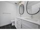 Modern bathroom featuring dual sinks, stylish mirrors, and sleek fixtures and dark tile floors at 5292 Columbine Ln, Denver, CO 80221