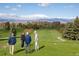 Scenic view of the golf course with lush green fairways and mountain views on a sunny day at 5292 Columbine Ln, Denver, CO 80221