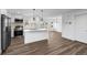 Modern kitchen boasts stainless steel appliances, a large island, and wood-look floors at 5292 Columbine Ln, Denver, CO 80221