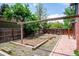 Backyard with garden beds, brick patio and wooden fence and gravel landscape at 6360 S Kendall St, Littleton, CO 80123