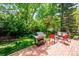 Charming brick patio with outdoor grill, swing, seating, and a well-maintained lawn surrounded by mature trees at 6360 S Kendall St, Littleton, CO 80123