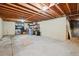 Unfinished basement with exposed wood beams, concrete floor, and ample storage space at 6360 S Kendall St, Littleton, CO 80123