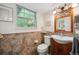 Charming bathroom featuring patterned tilework, a wooden vanity, and a decorative mirror at 6360 S Kendall St, Littleton, CO 80123