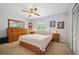 Bright bedroom with a floral-patterned bedspread, a ceiling fan, and large dresser at 6360 S Kendall St, Littleton, CO 80123