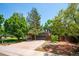 Exterior view of the property, showcasing the garage, driveway, and mature trees at 6360 S Kendall St, Littleton, CO 80123