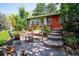 Inviting front yard with a swing, patio, and well-manicured landscaping and a red door at 6360 S Kendall St, Littleton, CO 80123