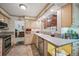 Well-lit kitchen featuring stainless steel appliances, light wood cabinetry, and a view to the exterior at 6360 S Kendall St, Littleton, CO 80123