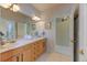 Bright bathroom with double sinks, wood cabinetry, and access to the glass block walk-in shower at 2035 Buchanan Pt, Lafayette, CO 80026