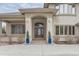 Elegant front entrance with an arched doorway, manicured shrubs, and symmetrical design at 2035 Buchanan Pt, Lafayette, CO 80026