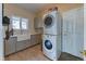 Functional laundry room with stacked washer and dryer, ample counter space, and a farmhouse sink at 2035 Buchanan Pt, Lafayette, CO 80026