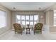 Bright living room with bay window showcasing snowy views and decorated with a table and upholstered arm chairs at 2035 Buchanan Pt, Lafayette, CO 80026