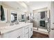 Bright bathroom featuring double vanity, white cabinets, modern fixtures, and glass shower with tile surround at 765 N Shawnee St, Aurora, CO 80018