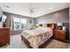 Comfortable bedroom with a ceiling fan, large window, gray walls, and wood furnishings at 765 N Shawnee St, Aurora, CO 80018