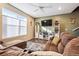 Cozy living room featuring large windows, ceiling fan and comfortable brown sofa at 765 N Shawnee St, Aurora, CO 80018