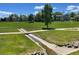 Scenic community park with grassy fields, mature trees, walking paths, and water drainage ditch at 13358 Briarwood Dr, Broomfield, CO 80020