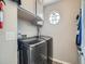 Functional laundry room with modern machines and a unique round window at 13358 Briarwood Dr, Broomfield, CO 80020